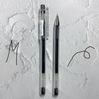 Two pens on a textured white surface with artistic lines.