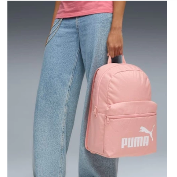 Person holding a pink Puma backpack with a plain background