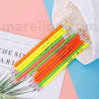 Neon-colored pencils on a magazine with a white bag in the background